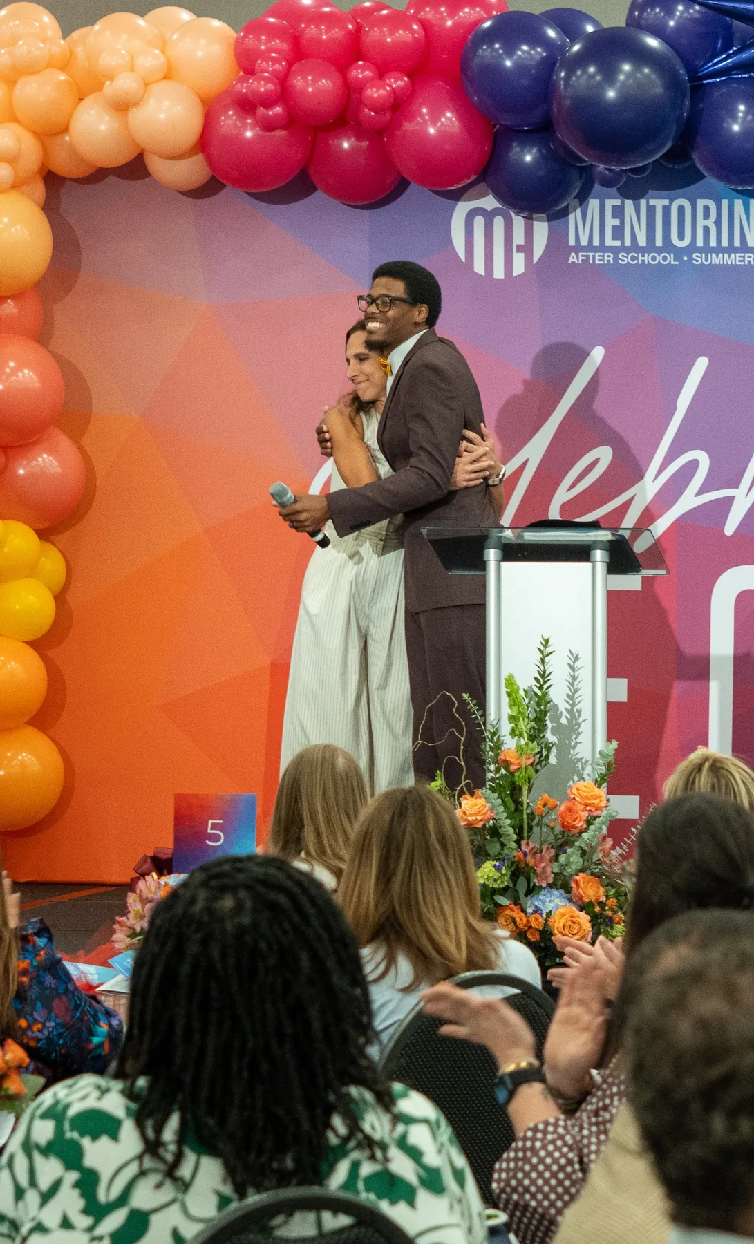 Ian Wade sharing a warm moment on stage during a Mentoring Alliance event
